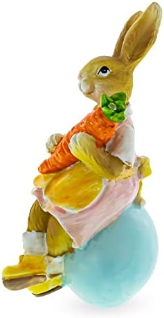 Bestpysanky majka zeko držala mrkvu i sjedeći na uskršnjoj egg figurini